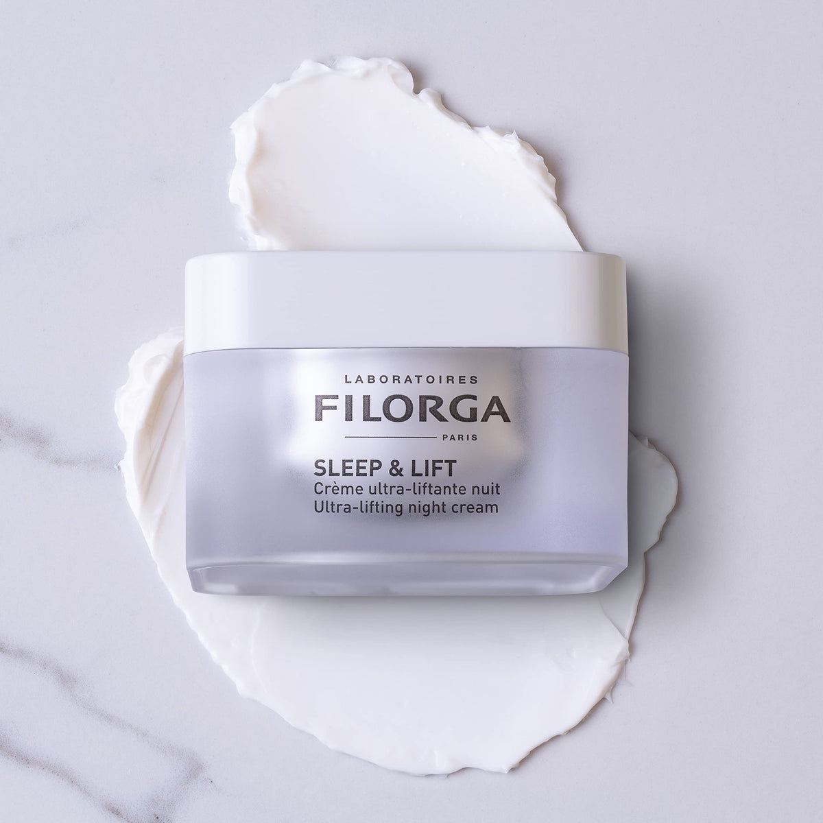 Filorga Sleep & Lift night cream jar on a white cream-texture background