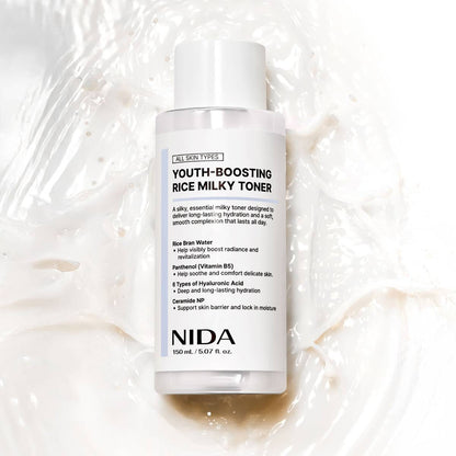 NIDA Youth-Boosting Rice Milky Toner 150 ml bottle on a creamy white textured background